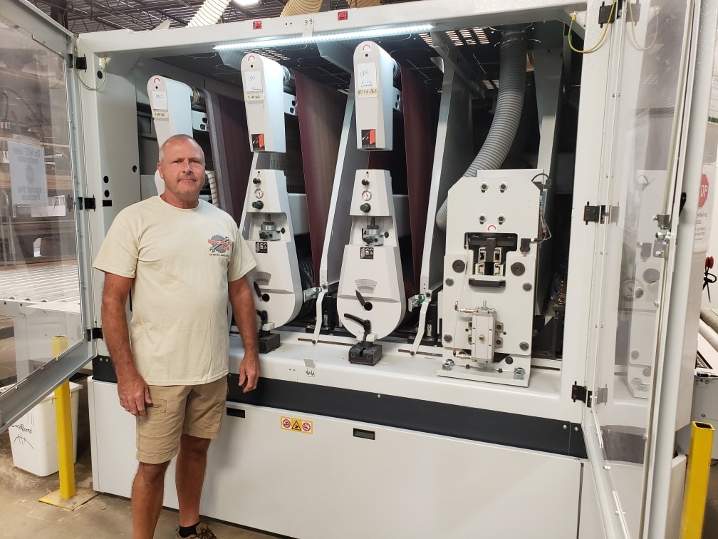 Chris Peterson with wide belt sander open for service